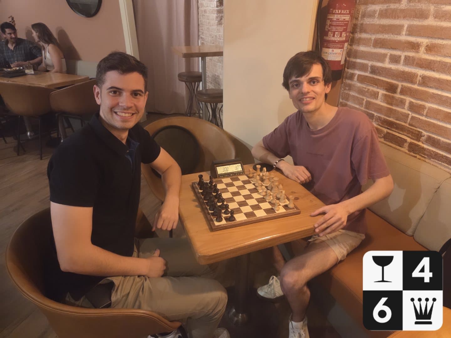 Dos jugadors somrient davant del tauler al Bar 64